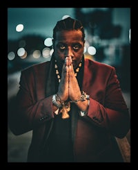 a man in a red suit with his hands on his knees